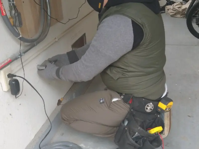 Electrician performing outlet wiring in a Marshall garage
